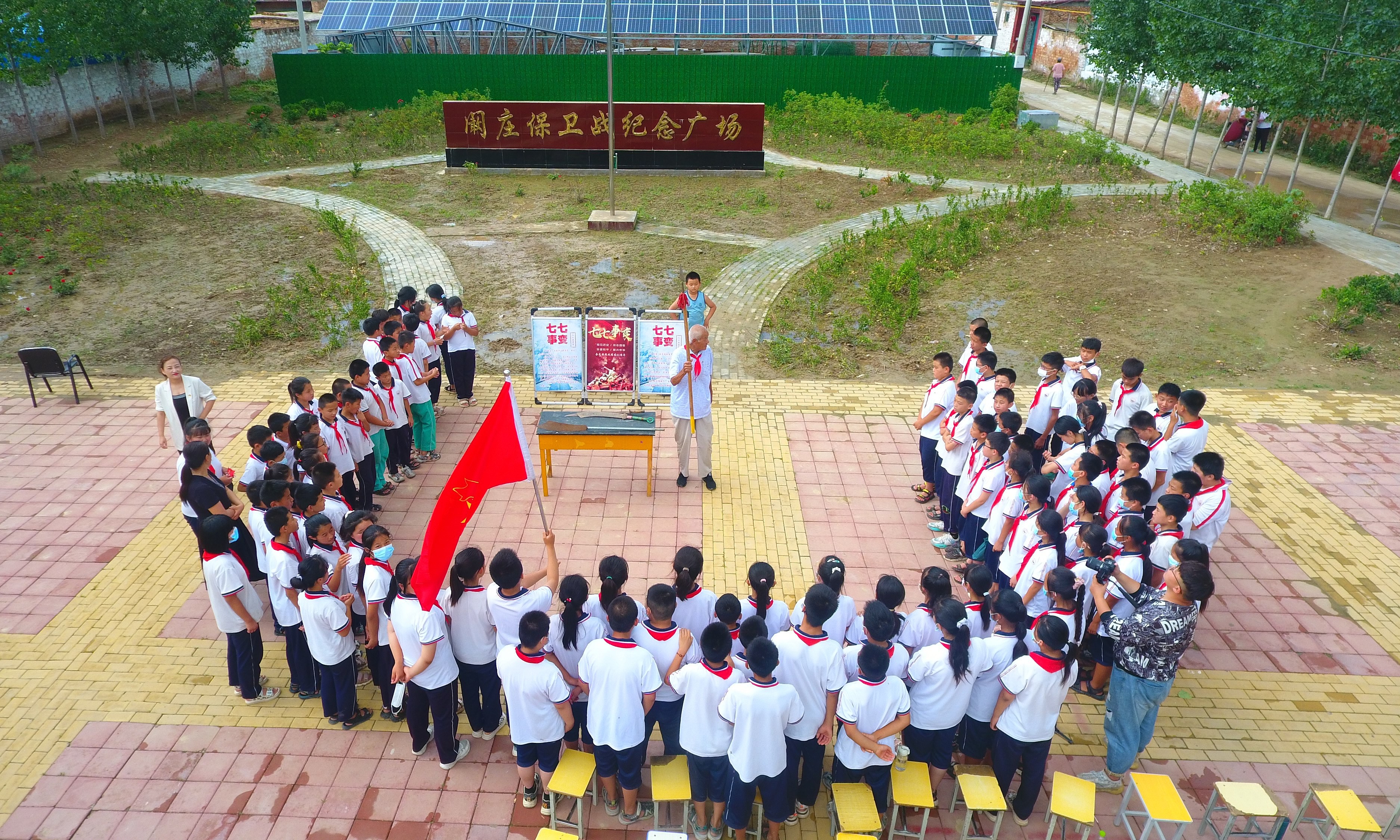 2022年7月6日，山東省聊城市，在茌平區菜屯鎮闞莊村的闞莊保衛戰紀念廣場(chǎng)，闞莊保衛戰親歷者王光木老人，為小學(xué)生們講述抗戰故事，展示大刀、長(cháng)矛。
