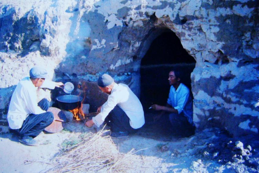 1983年，“六老漢”一代治沙人在“地窩子”生活做飯。新華社發(fā)（八步沙林場(chǎng)供圖）
